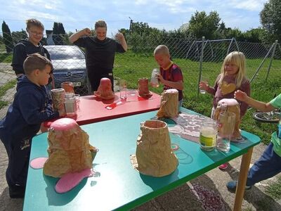 Wychowankowie z PWD z Lasek wykonują doświadczenie "Wybuchający wulkan".