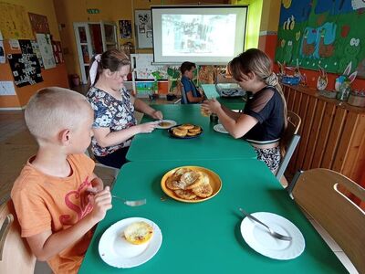 Wychowankowie z PWD z Lasek degustują placki z cukinii.