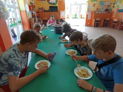 Wychowankowie z PWD z Lasek degustują sałatkę z kurczakiem.