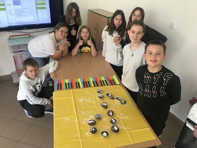 Uczniowie z klasy 7 z upieczonych babeczek ułożyli nutkę - ósemkę.