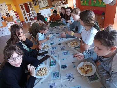 Wychowankowie z PWD z Lasek degustują zapiekankę makaronową.