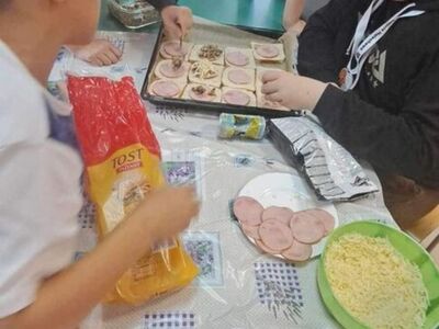 Wychowankowie z PWD z Lasek robią tosty z wędliną, serem i warzywami.