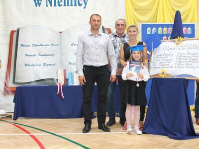 Uczennica klasy pierwszej z rodzicami.