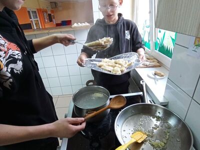 Wychowankowie z PWD z Lasek gotują pierogi.