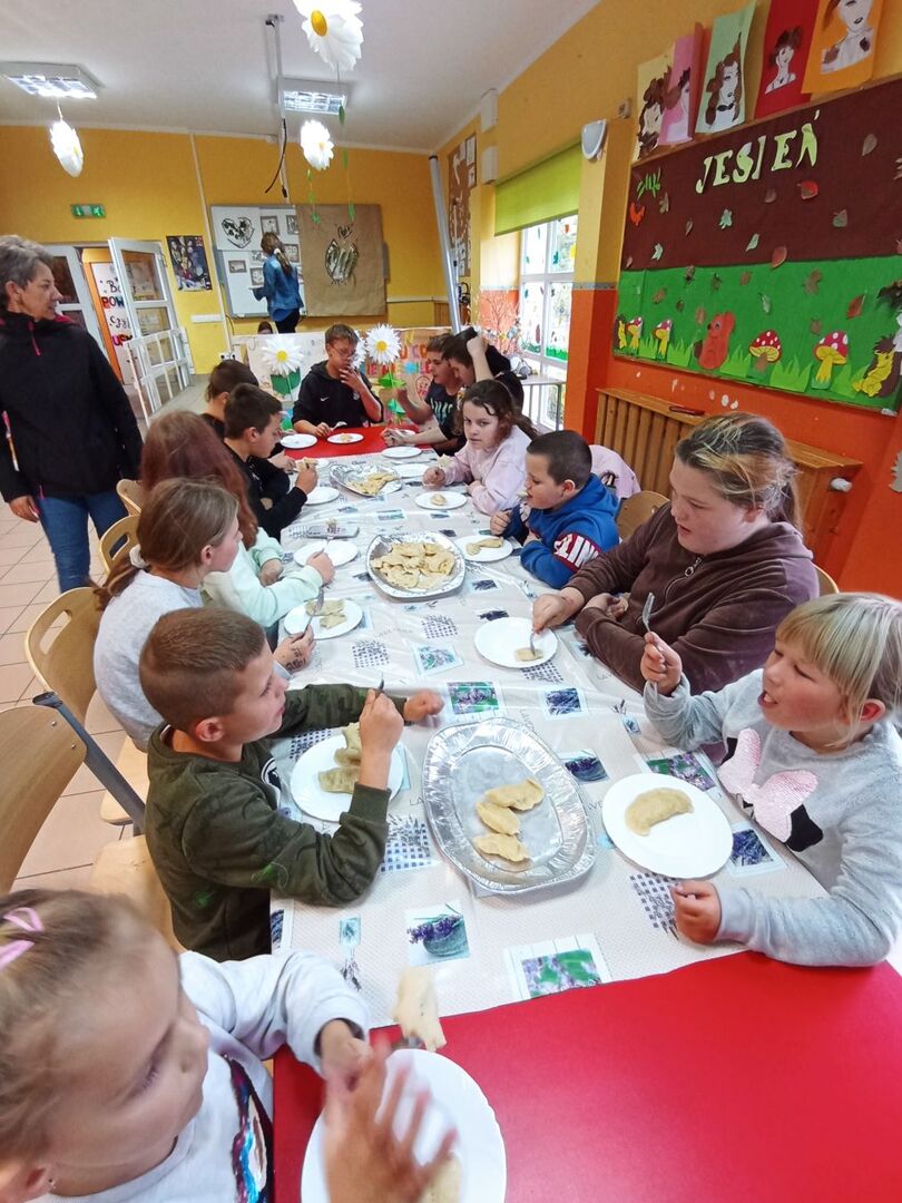 Wychowankowie z PWD z Lasek degustują pierogi.