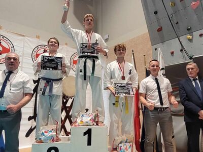 Na podium zawodnicy turnieju wraz z dyplomami oraz sędziowie.