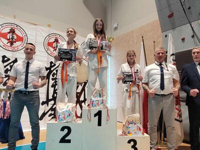 Na podium uczestniczki turnieju z pucharami i dyplomami oraz sędziowie.