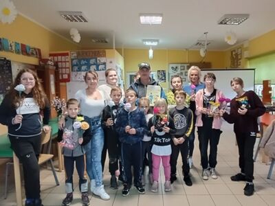 Wychowankowie z PWD z Lasek pozują do zdjęcia wraz z listonoszem i wychowawcami.