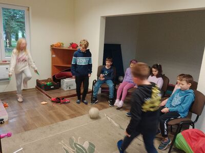 Odegranie scenki - dziewczynka skacze na skakance, chłopcy grają w piłkę. Na krzesłach widownia.