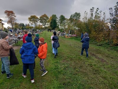 Dzieci w trakcie porządkowania terenu cmentarza.