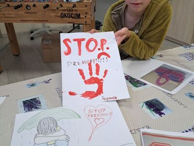 Szymon prezentuje plakat ,,Stop przemocy''.