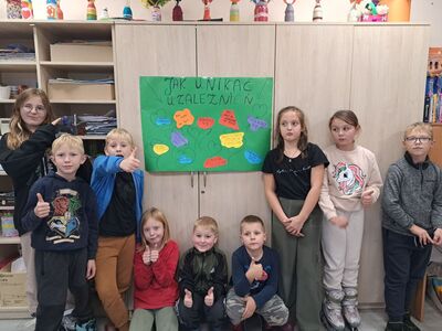 Dzieci przy wykonanym wspólnie plakacie "Jak unikać uzależnień".