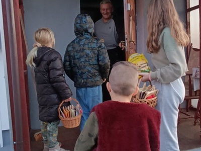 Wychowankowie wręczają prezent seniorowi z Lasek.