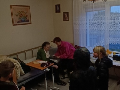 Wychowankowie wręczają prezent seniorowi z Lasek.