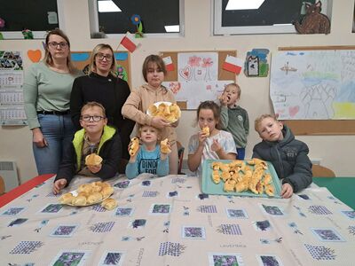 Dzieci z mamami z Placówki Wsparcia Dziennego w Niemicy prezentują upieczone rogaliki.