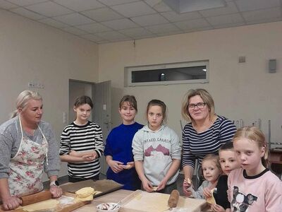 Dzieci z Placówki Wsparcia Dziennego w Niemicy z wychowawczynią i paniami z KGW przy rogalikach.