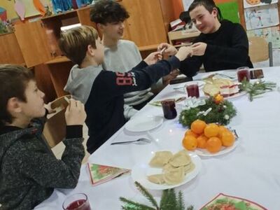 Dzieci dzielą się opłatkiem i składają życzenia 