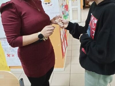 Dzieci dzielą się opłatkiem i składają życzenia.