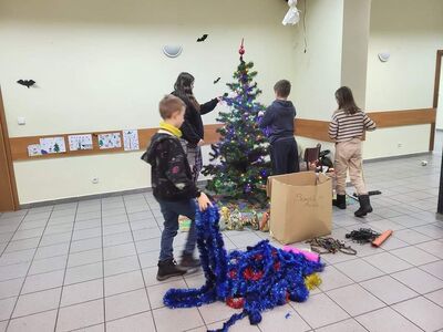 Wychowankowie zakładają łańcuch na choinkę.