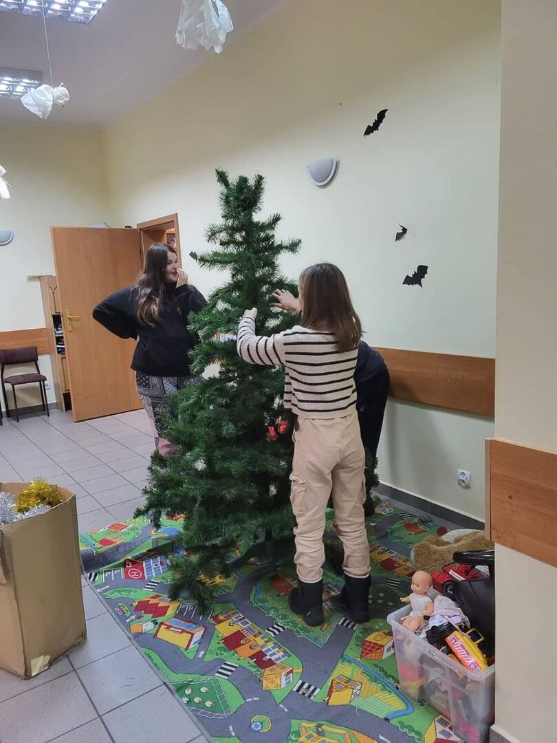 Dziewczynki ubierają choinkę.