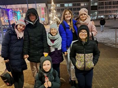 Dzieci przed koszalińskim ratuszem. W tle choinka.
