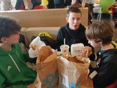 Dzieci jedzą ciepły posiłek w McDonald's.