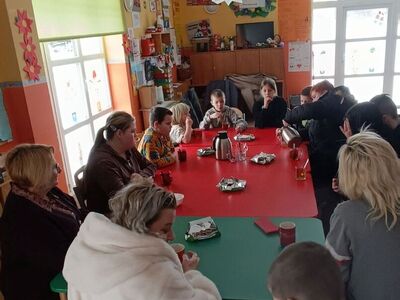 Dzieci wraz z rodzicami podczas rozmowy z panią Elżbietą Karnicką.