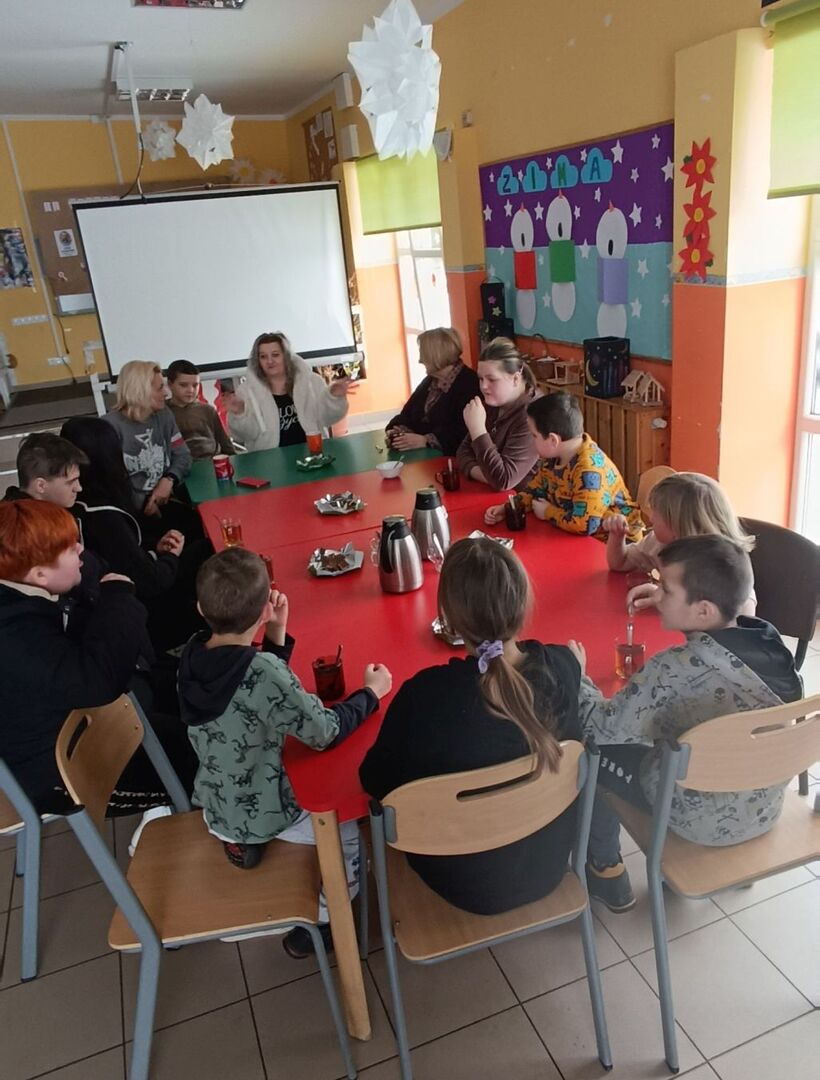 Dzieci wraz z rodzicami podczas rozmowy z panią Elżbietą Karnicką.