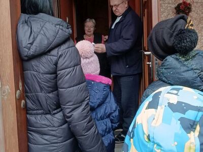 Wychowankowie wręczają mieszkańcom własnoręcznie wykonane lizaki.
