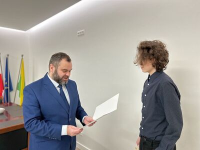Wójt Radosław Nowakowski odczytuje list gratulacyjny, obok nagrodzony Stanisław Rogala.