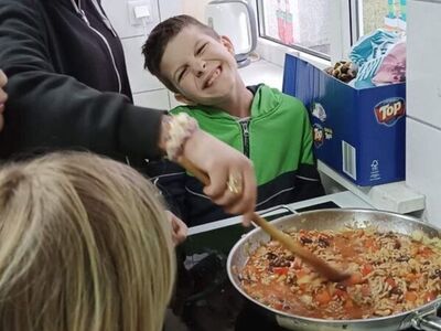 Wychowankowie z pomocą wychowawcy przygotowują sos.
