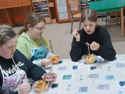 Dzieci degustują spaghetti.