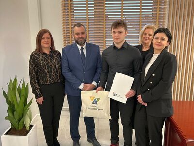 Nagrodzony sportowiec Bartłomiej Podbereżny w gabinecie wójta Radosława Nowakowskiego, przyjmuje od niego gratulacje. Towarzyszą mu: kierownik Referatu Oświaty i Sportu - Karolina Chruszcz-Pietraszewska, zastępca wójta - Halina Skaza i mama sportowca - Monika Podbereżna.