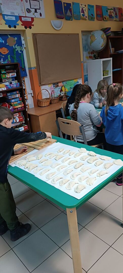 Dzieci lepią pierogi.