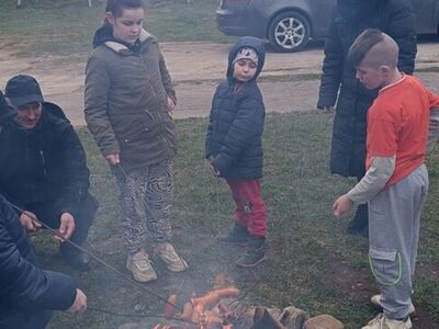 Dzieci podczas rozpalania ogniska i smażenia kiełbas.