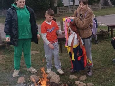 Dzieci podczas rozpalania ogniska i smażenia kiełbas.