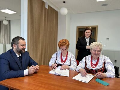 Wójt Radosław Nowakowski z przedstawicielkami Zespołu Ludowego Ostrowianie podczas podpisania umów.