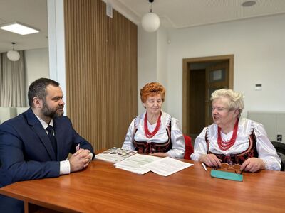 Wójt Radosław Nowakowski z przedstawicielkami Zespołu Ludowego Ostrowianie podczas podpisania umów.