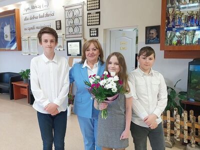 Dyrektor szkoły z uczniami przed powitaniem Biskupa.