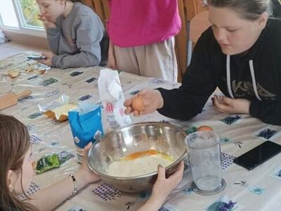 Dziewczynki przygotowują składniki na ciasto.