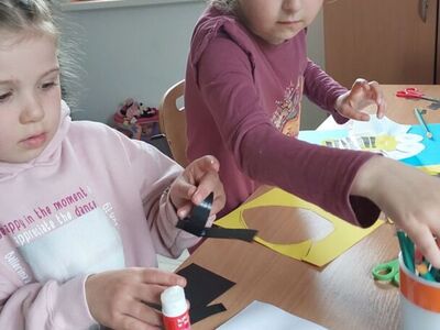 Dzieci wyklejają z papieru elementy pszczółki.
