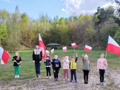 Dzieci pozują do zdjęcia z flagami Polski.