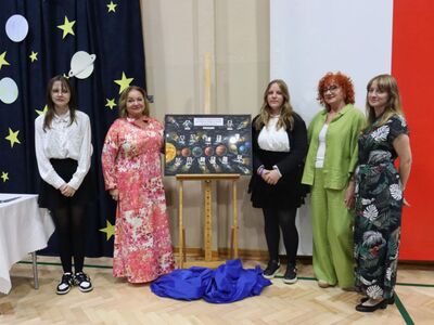 Dyrektor szkoły, Wychowawca i przedstawiciele uczniów przy pamiątkowym tablo.