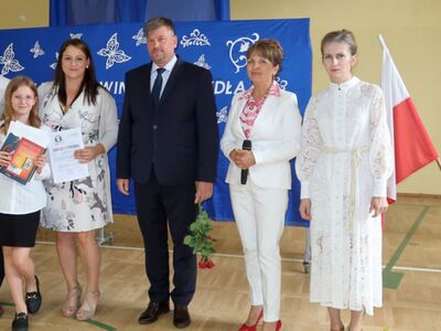 Pamiątkowe zdjęcia uczennicy i jej rodziców z wójtem Krzysztofem Jarotkiem, dyrekcją szkoły i wychowawczynią. 