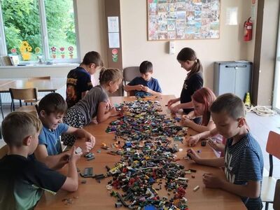 Zdjęcia przedstawiają dzieci układające klocki Lego.