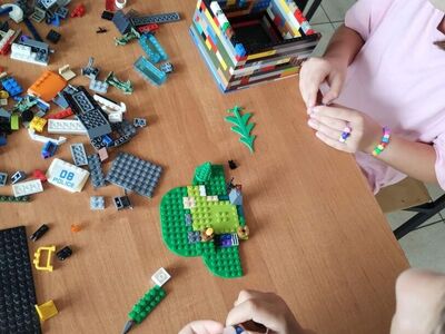 Zdjęcia przedstawiają dzieci układające klocki Lego.