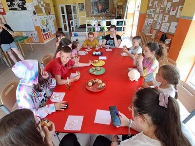 Dzieci degustują babeczki z czekoladą. 