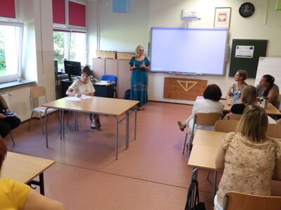 Na zdjęciach widoczni są nauczyciele podczas intensywnego szkolenia. W trakcie sesji opracowują nowoczesne modele uczenia się, pracując w grupach eksperckich. Widać ich zaangażowanie i współpracę, siedząc w klasie zapisują na kartkach i dzieląc się wiedzą oraz doświadczeniami.