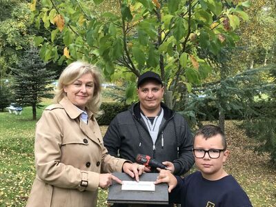 Antek Kopiecki, pani dyrektor Mirosława Turczyn oraz pan Karol uroczyście mocują pierwszą tabliczkę.