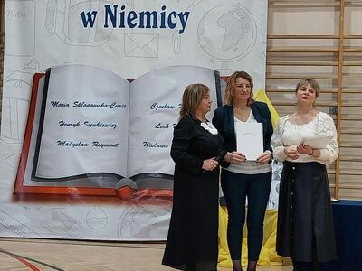 Dyrektor przyznaje nagrodę nauczycielowi.